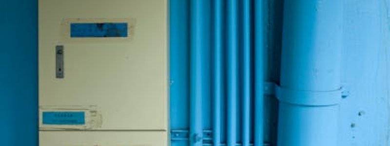 A close-up view of an industrial electric distribution board with blue pipes, emphasizing urban infrastructure.