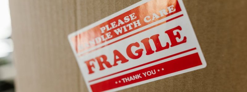 Close-up of a cardboard box with a 'fragile' sticker indicating careful handling.